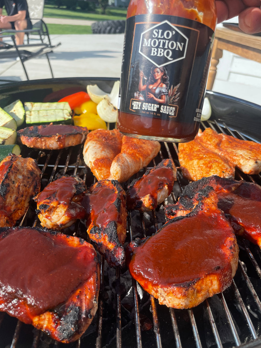 Grilled meat with a bottle of Slo Motion BBQ Hey Sugar sauce being poured over it